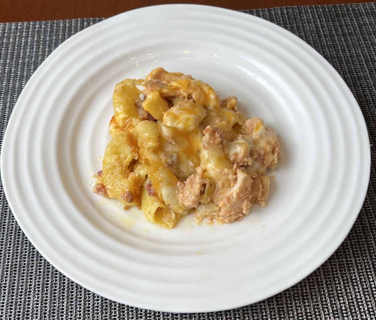 Image of cooked chicken and bacon mac and cheese served on a white plate.