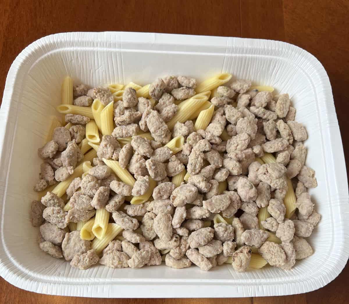 Image of a tray of pasta with Italian sausage crumbles scattered on top. 