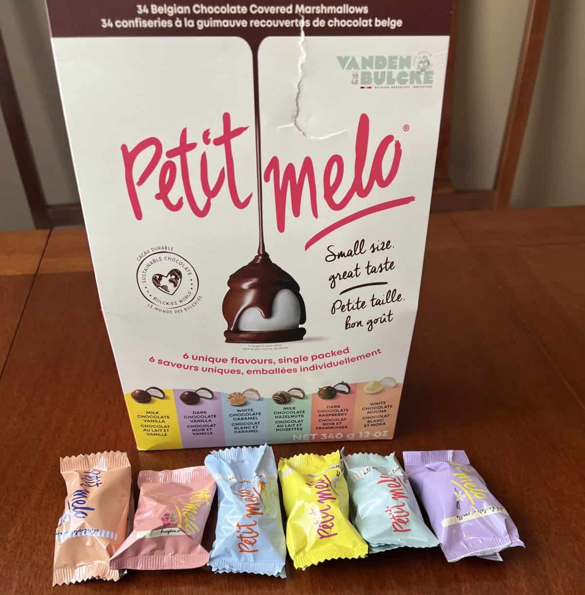 Image of the box of Petit Melo sitting on a table with six individually wrapped Petit Melo sitting in front of the box.