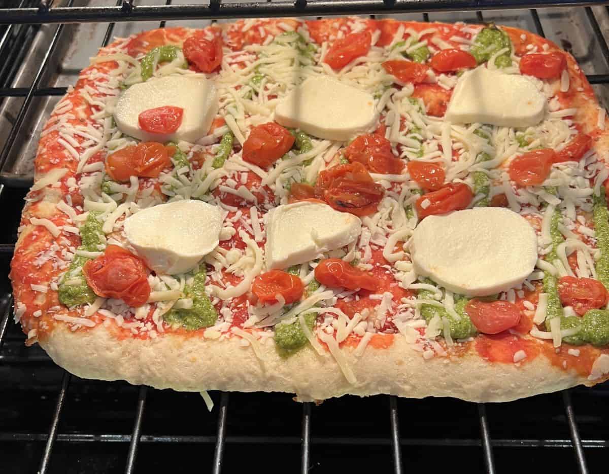 Image of the Margherita Pinsa from Costco being baked in an oven directly on the oven rack.