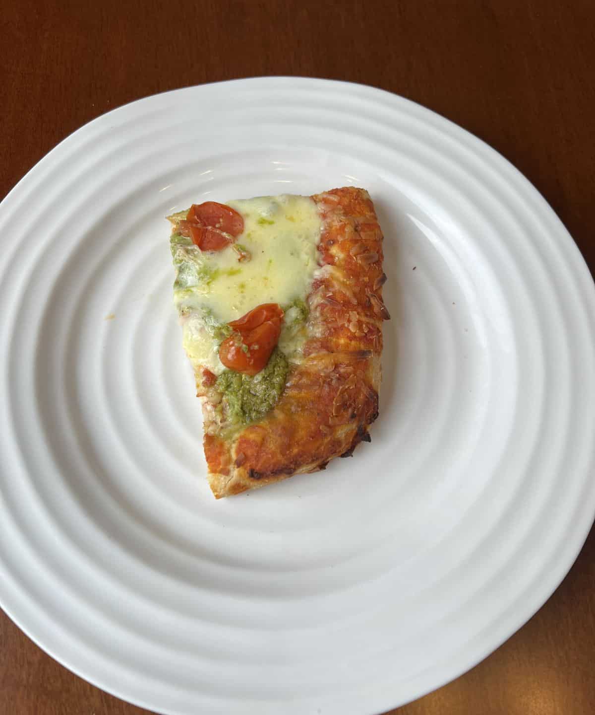 Image of one slice of Pinsa served on a white plate.