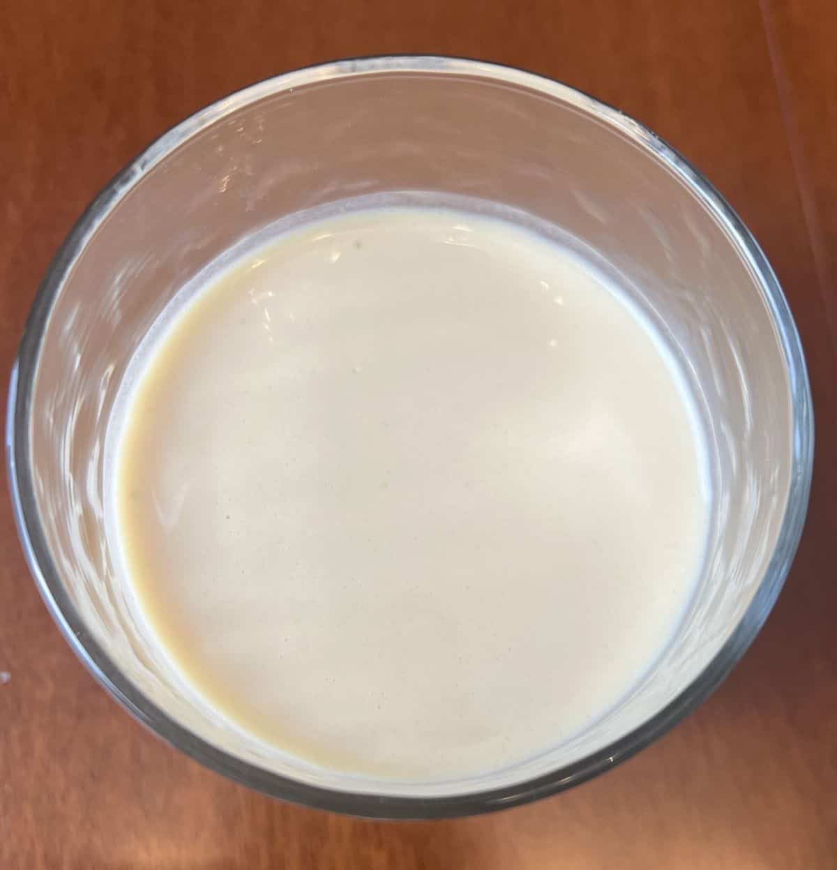 Top down image of a glass with a protein shake in the glass. 