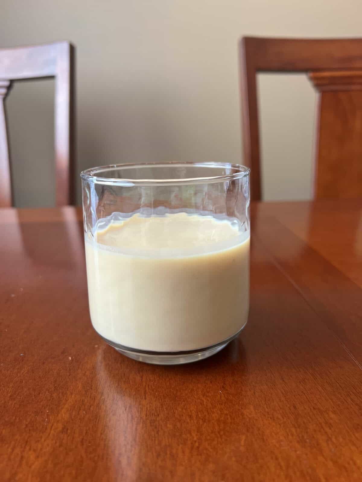 Closeup image of a clear glass with a protein shake in the glass.