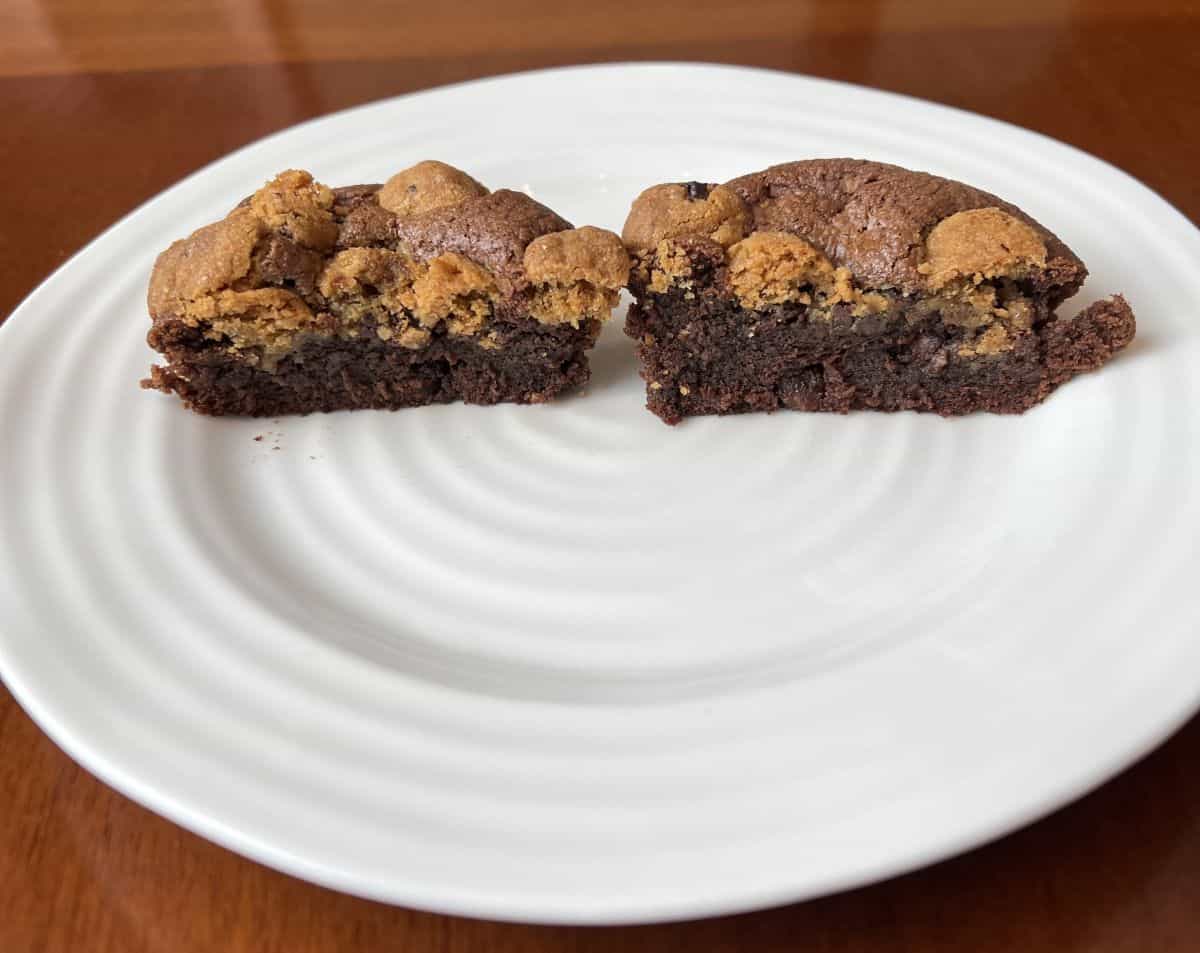 Image of a Brookie served on a white plate cut in half so you can see the center of the brownie.