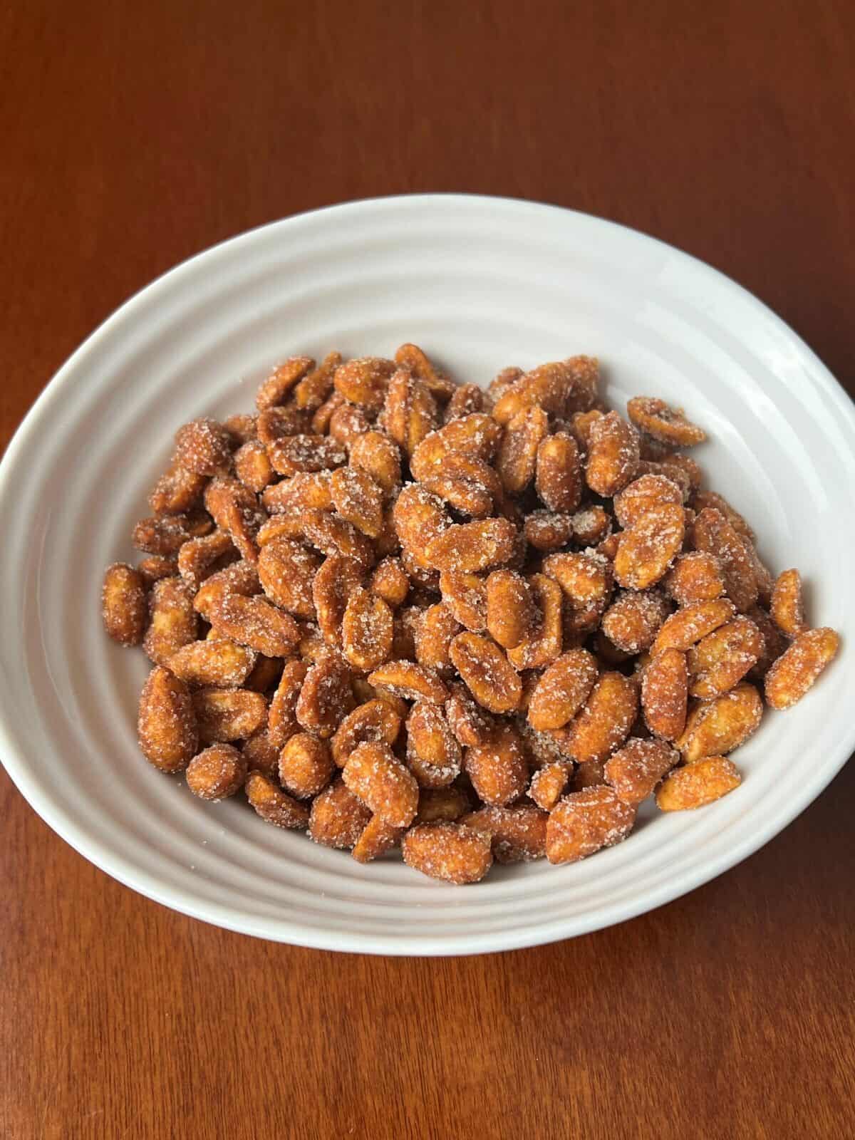 Top down image of a bowl of honey roasted peanuts.