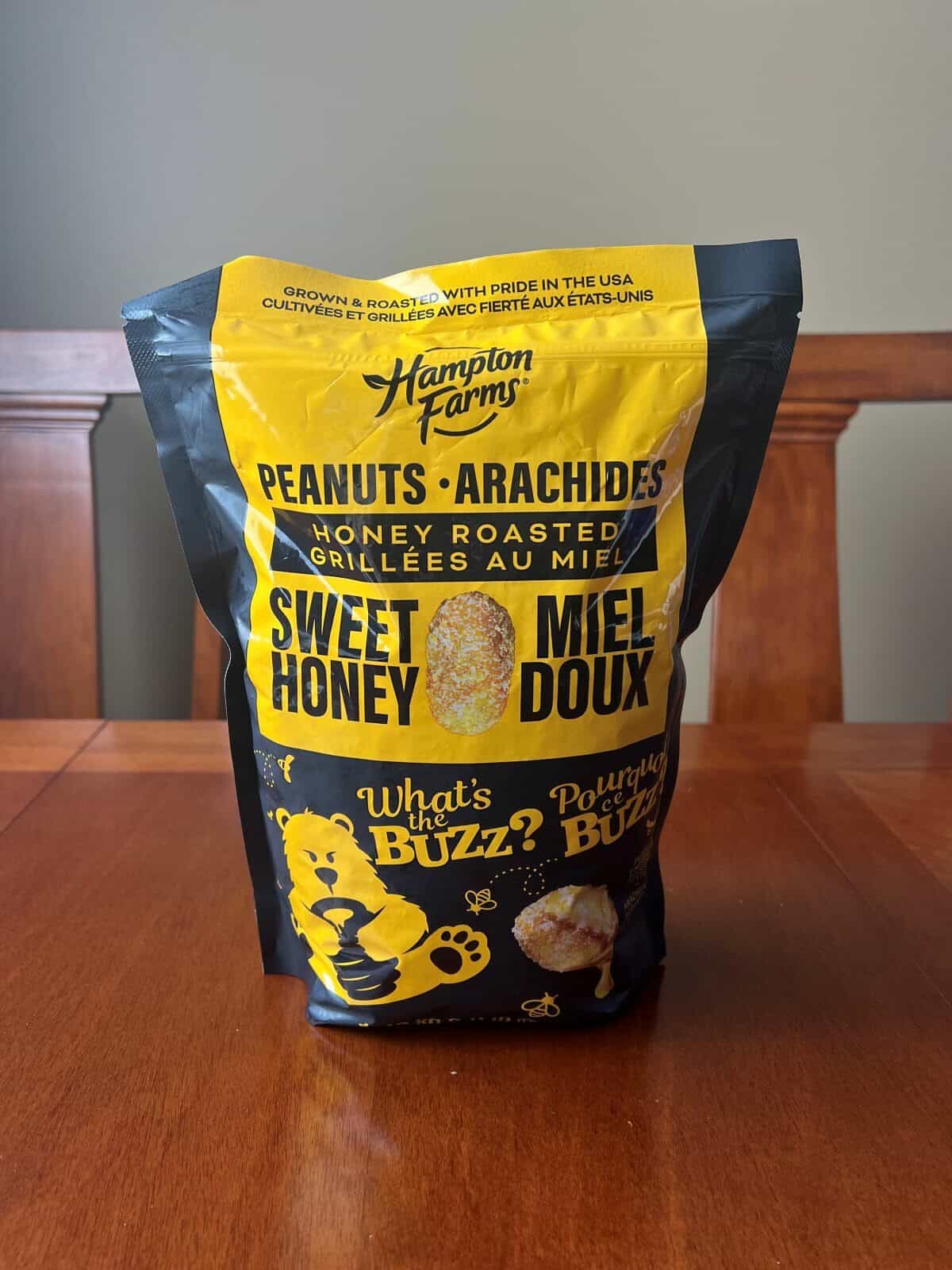 Image of the Costco Hampton Farms Honey Roasted Peanuts bag sitting on a table unopened. 