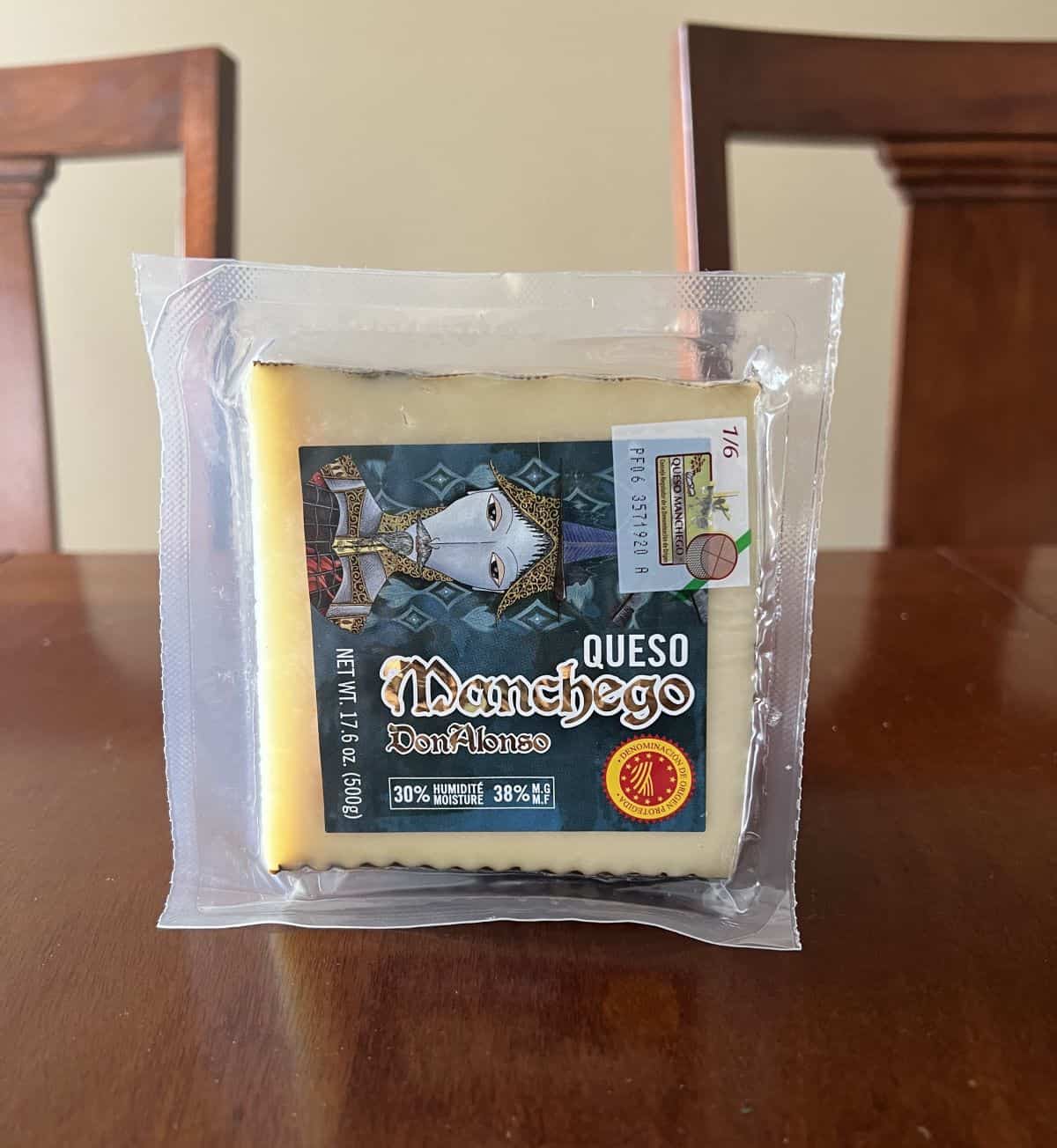 Image of the Costco Don Alonso Manchego Queso sitting on a table unopened. 