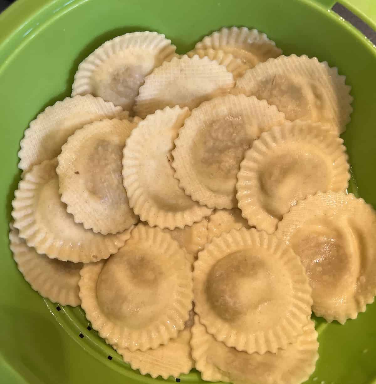 Image of the ravioli after being boiled sitting in a colander after being drained.